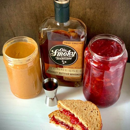 Not your mom's pb&j cocktail with a jar of pb, jelly, peanut butter whiskey and a shot glass