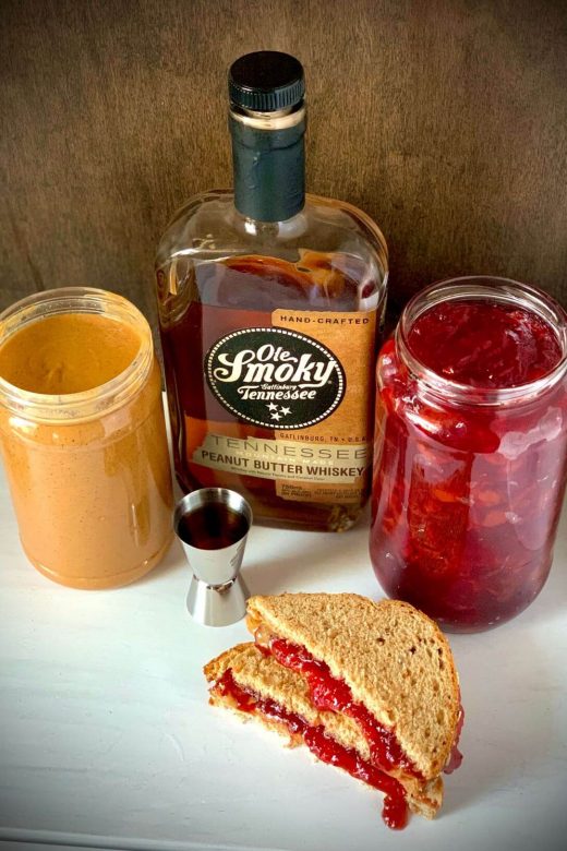 Not your mom's pb&j cocktail with a jar of pb, jelly, peanut butter whiskey and a shot glass