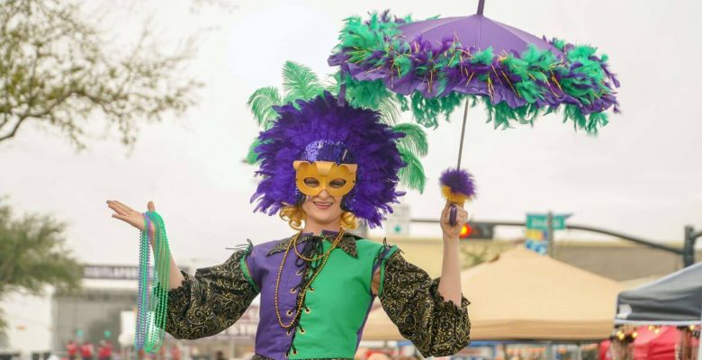 Picture of a Mardi Gras jester holding an umbrella and beads in Galveston, TX